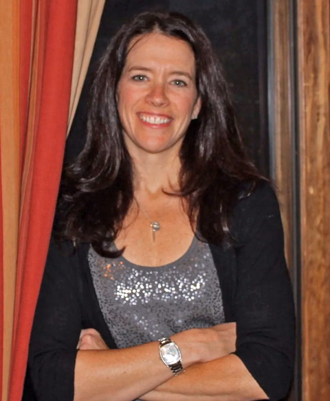 Dr. Kristen Scurlock, smiling with her arms folded, wearing a dark cardigan